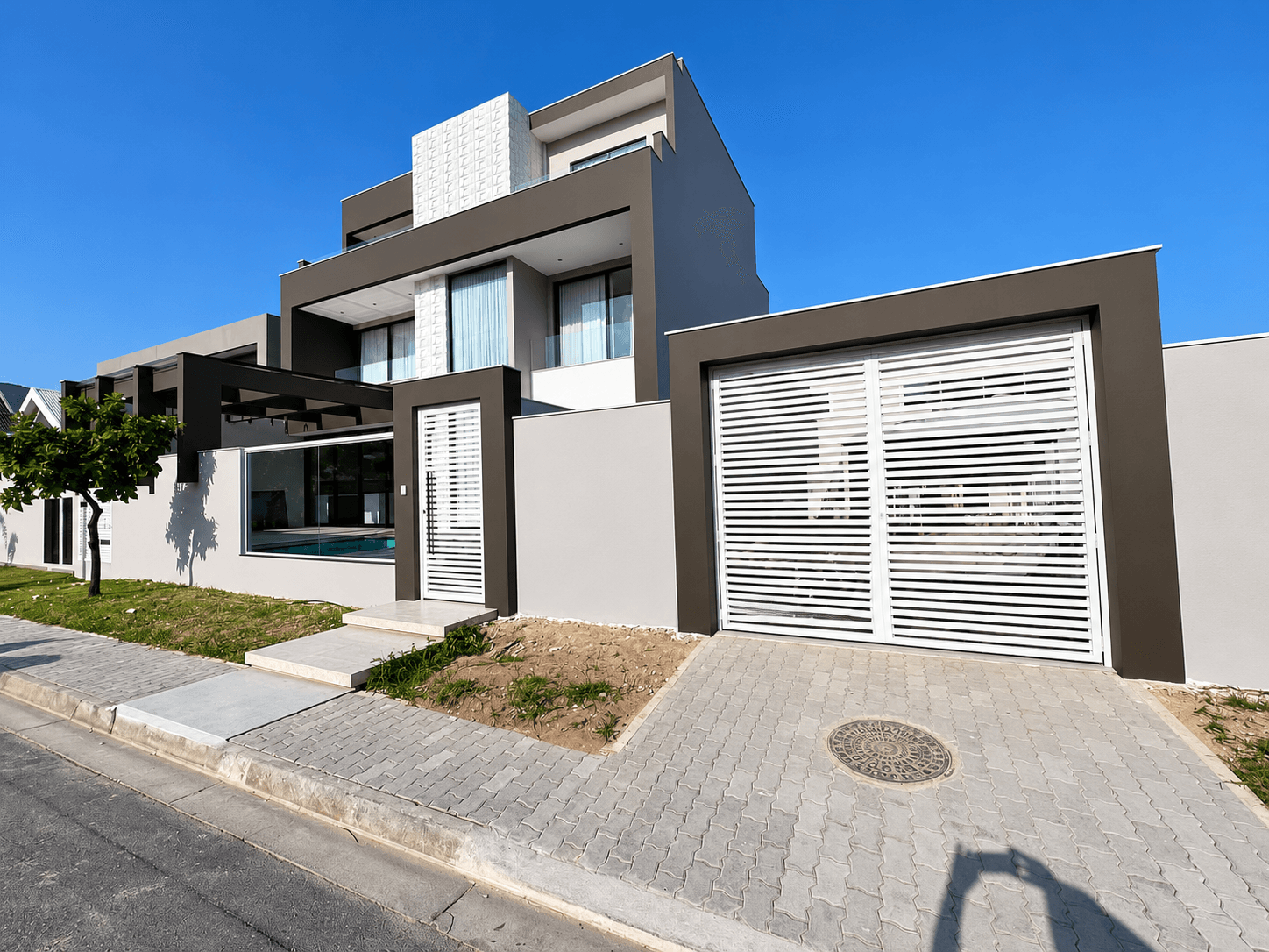 Fachada de residência contemporânea com esquadrias, vidro e portões brancos