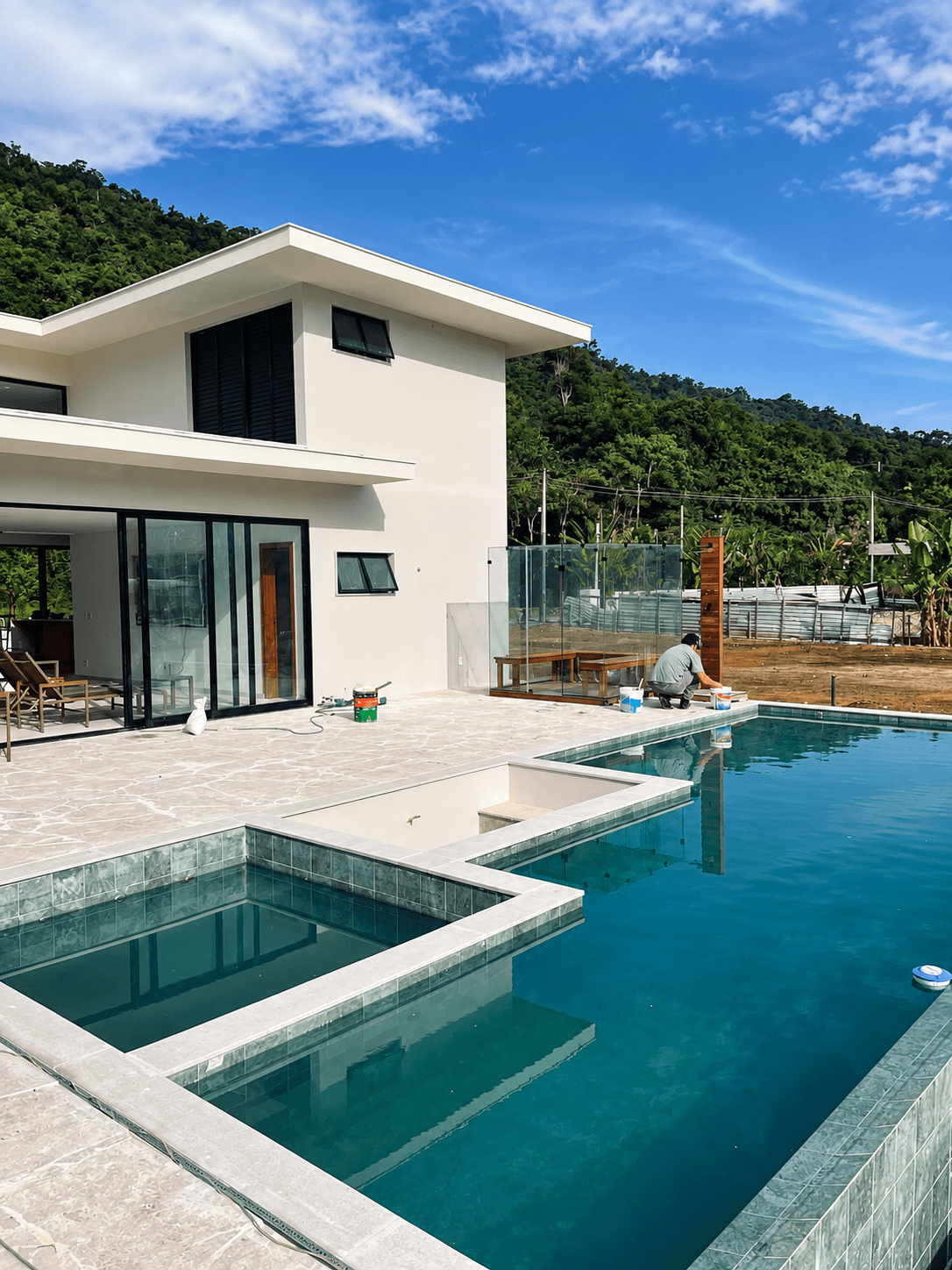 Casa branca com portas de vidro e piscina em área externa